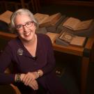 Fran Dolan portrait, with open books in background.